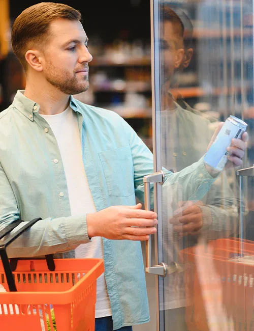 man checking label on canned drink