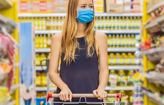 woman grocery shopping with mask on