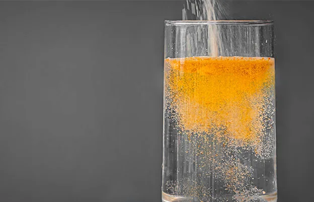 orange instant powder drink mix being poured into glass
