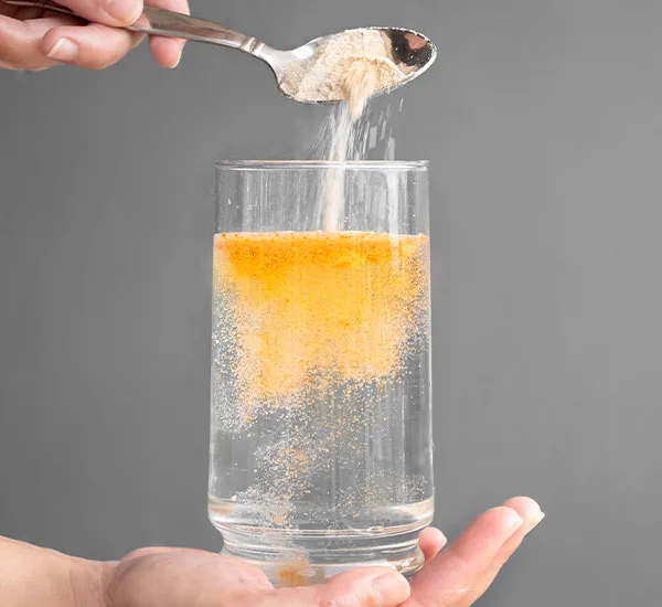 orange powder in water being dissolved