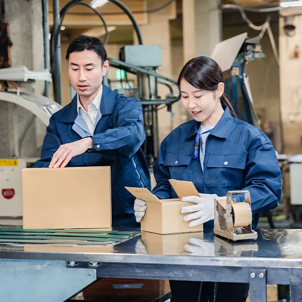 two people packaging boxes on an assembly line